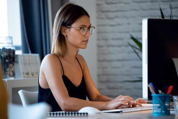 Shot of cute freelance business woman seller working with computer in her startup small business.